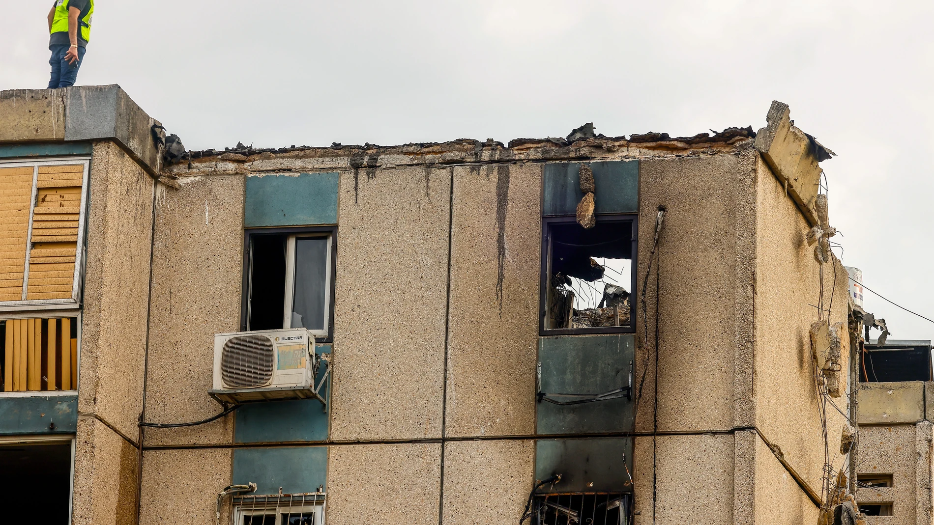 Tel Aviv (Israel), 27/10/2023.- An Israeli rescuer worker stands on the roof of a damaged building after it was hit by a rocket, in Tel Aviv, Israel, 27 October 2023. According to the United Hatzalah volunteer emergency reactions team spokesperson in a statement on 27 October, at least three people were injured following a direct rocket hit on an apartment building in Tel Aviv. More than 7,000 Palestinians and at least 1,300 Israelis have been killed, according to the Israel Defense Forces (I...