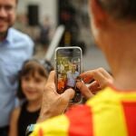 Un hombre con la camiseta del Barça fotografía al presidente de la Generalitat, Pere Aragonès, con dos niños