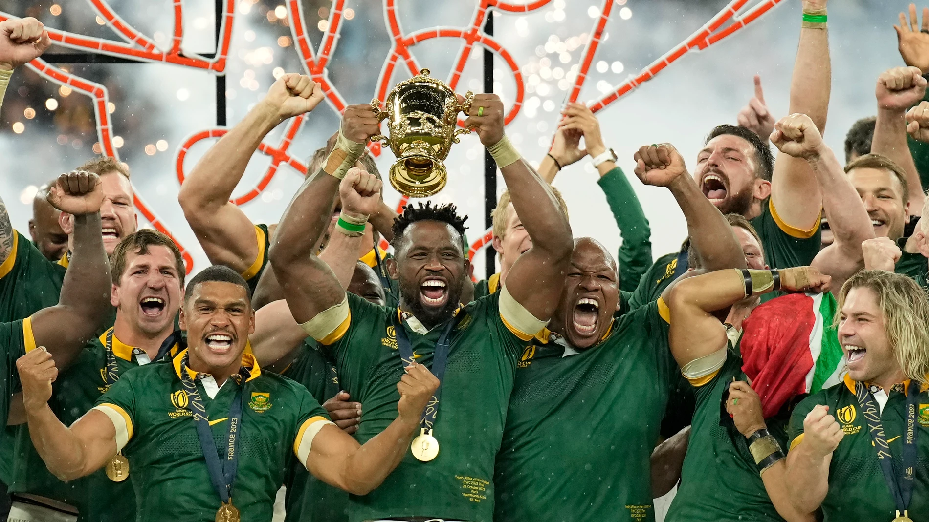 South Africa's Siya Kolisi lifts the trophy as teammates celebrate after they won the Rugby World Cup final match between New Zealand and South Africa at the Stade de France in Saint-Denis, near Paris Saturday, Oct. 28, 2023. South Africa won the game 12-11. (AP Photo/Christophe Ena)