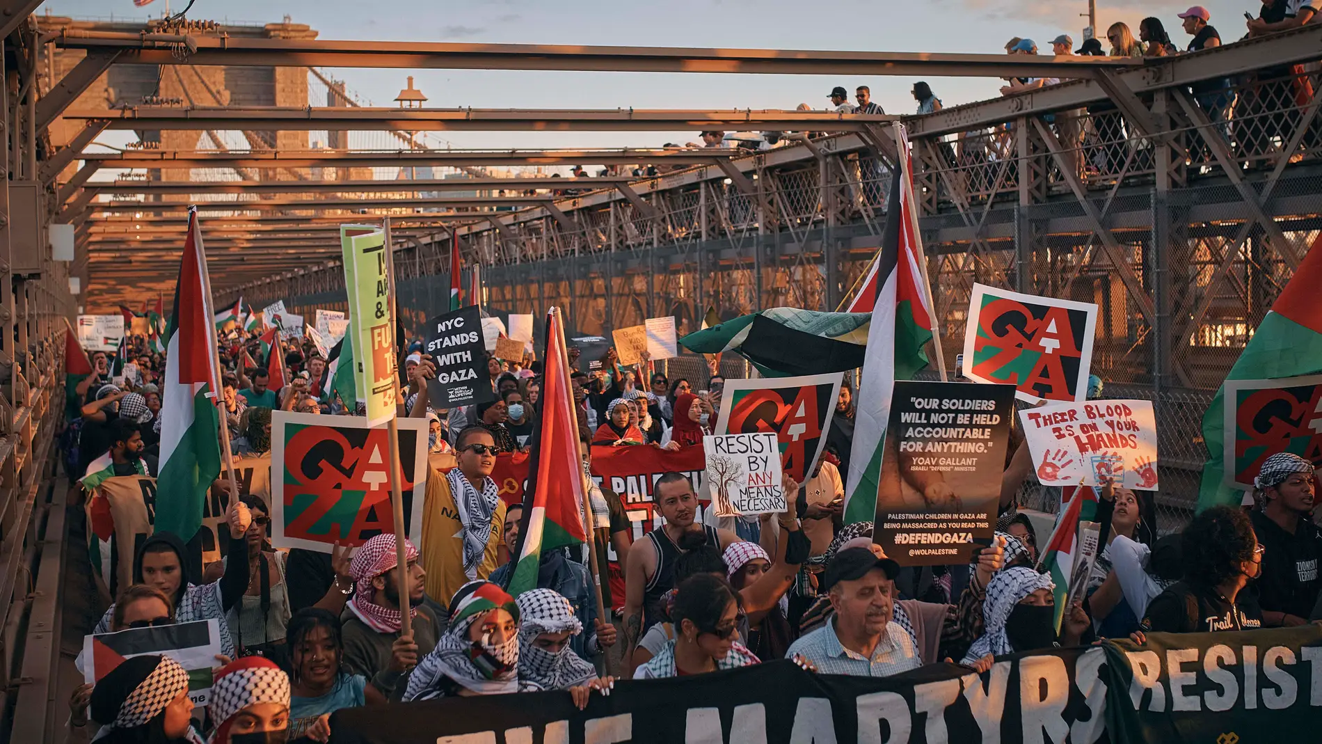 Palestinian supporters carry placards while shouting slogans as they cross Brooklyn Bridge during a demonstration demanding a cease-fire on Saturday, Oct. 28, 2023, in New York. (AP Photo/Andres Kudacki)