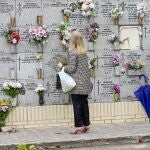 Personas limpian y colocan flores en el cementerio de la Almudena en Madrid.- EFE/ Víctor Lerena