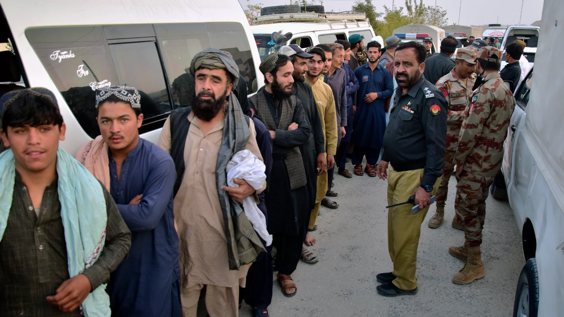 Security officials stand guard as detained Afghan immigrants wait for their registration process at a deportation center, setup by authorities to facilitate illegal immigrants, in Quetta, Pakistan, Wednesday, Nov. 1, 2023. Pakistani security forces on Wednesday rounded up, detained and deported dozens of Afghans who were living in the country illegally, after a government-set deadline for them to leave expired, authorities said. (AP Photo/Arshad Butt)
