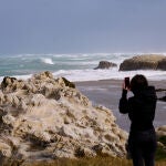 Una persona fotografía las olas rompiendo en Santander, Cantabria (España