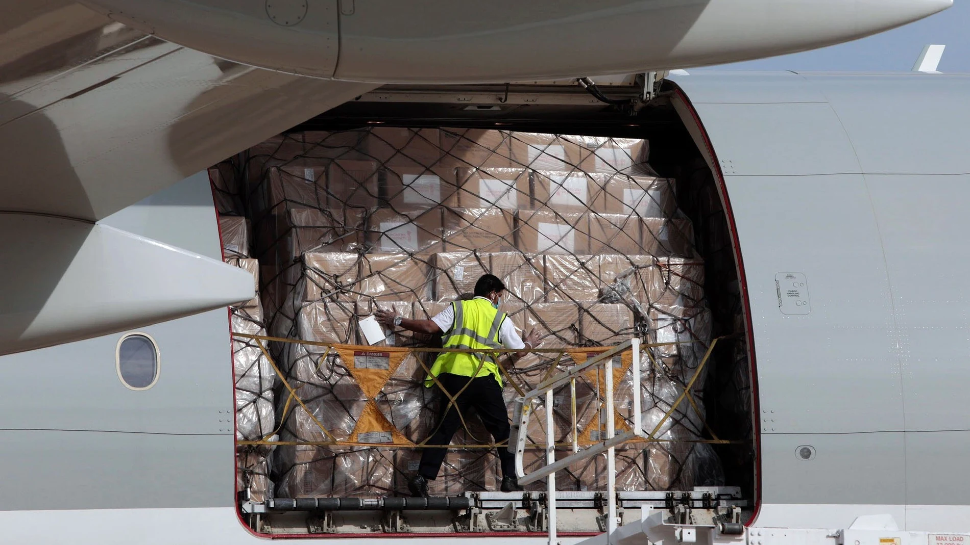 Un operario trabaja en la descarga de material sanitario en uno de los aviones que llegó durante la pandemia al aeropuerto de Valencia