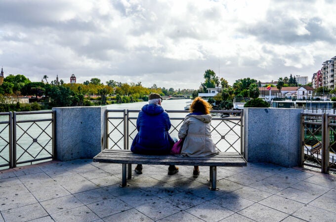 Una pareja de anciano sentados en un banco del Puente de San Telmo