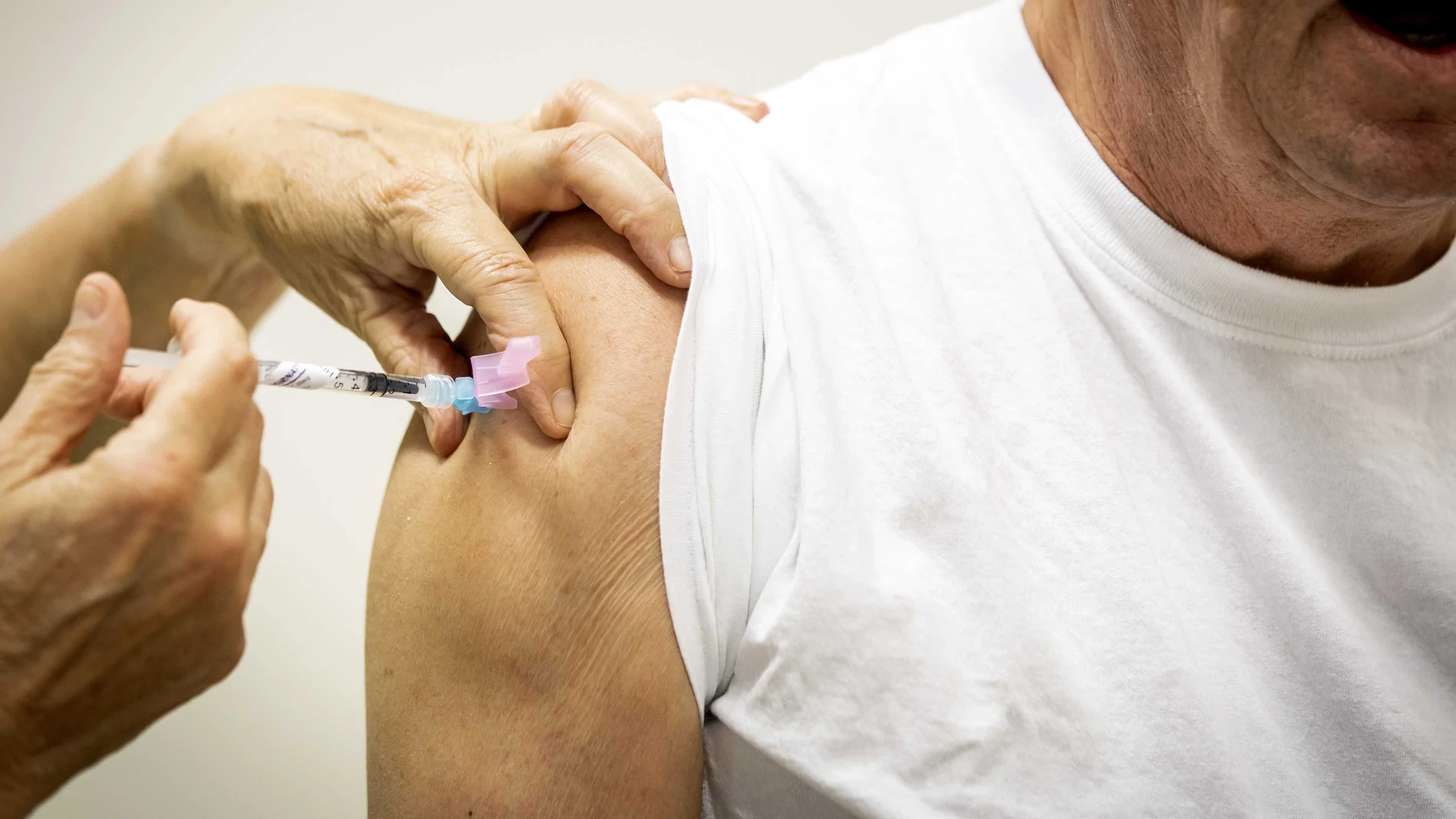 An elderly person receives a dose of coronavirus disease (COVID-19) vaccine.