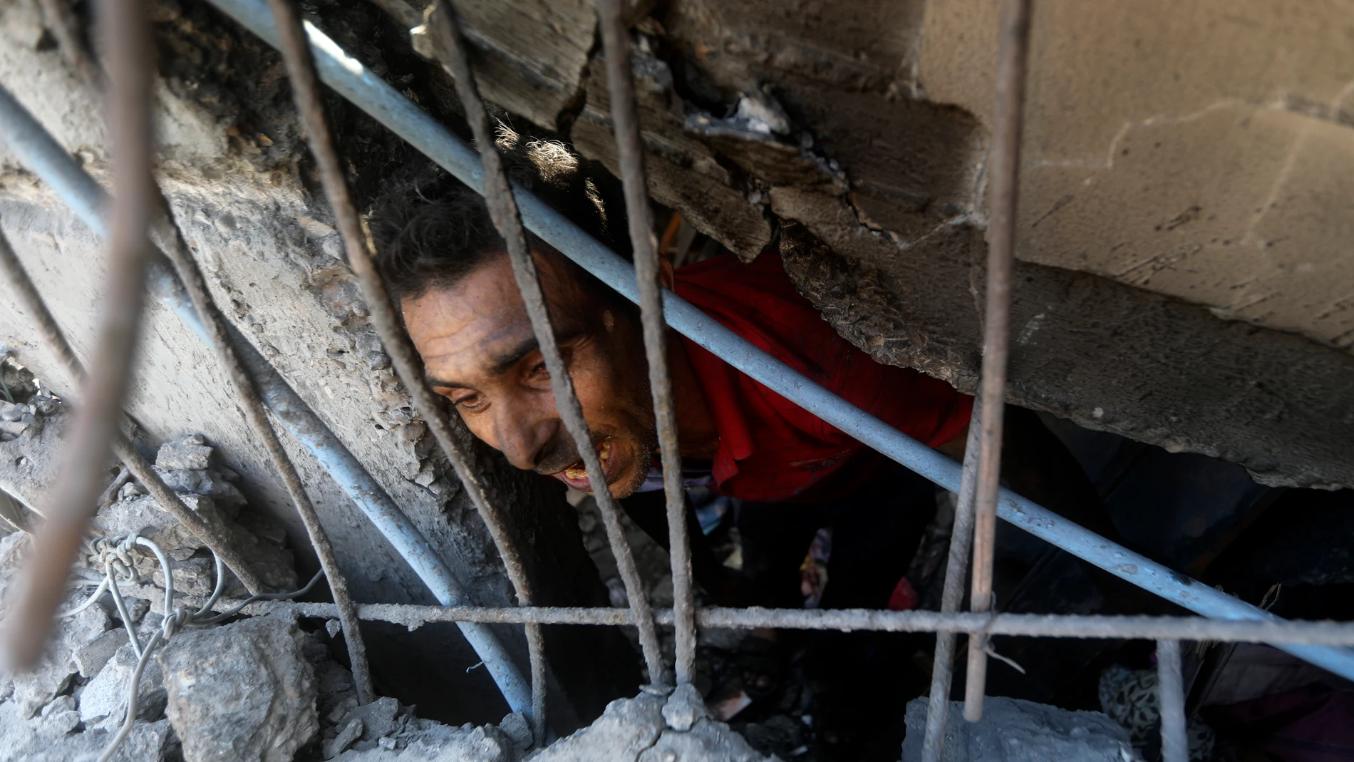 Palestinos buscan supervivientes bajo los escombros de un edificio destruido tras un ataque aéreo israelí en el campo de refugiados de Jan Yunis