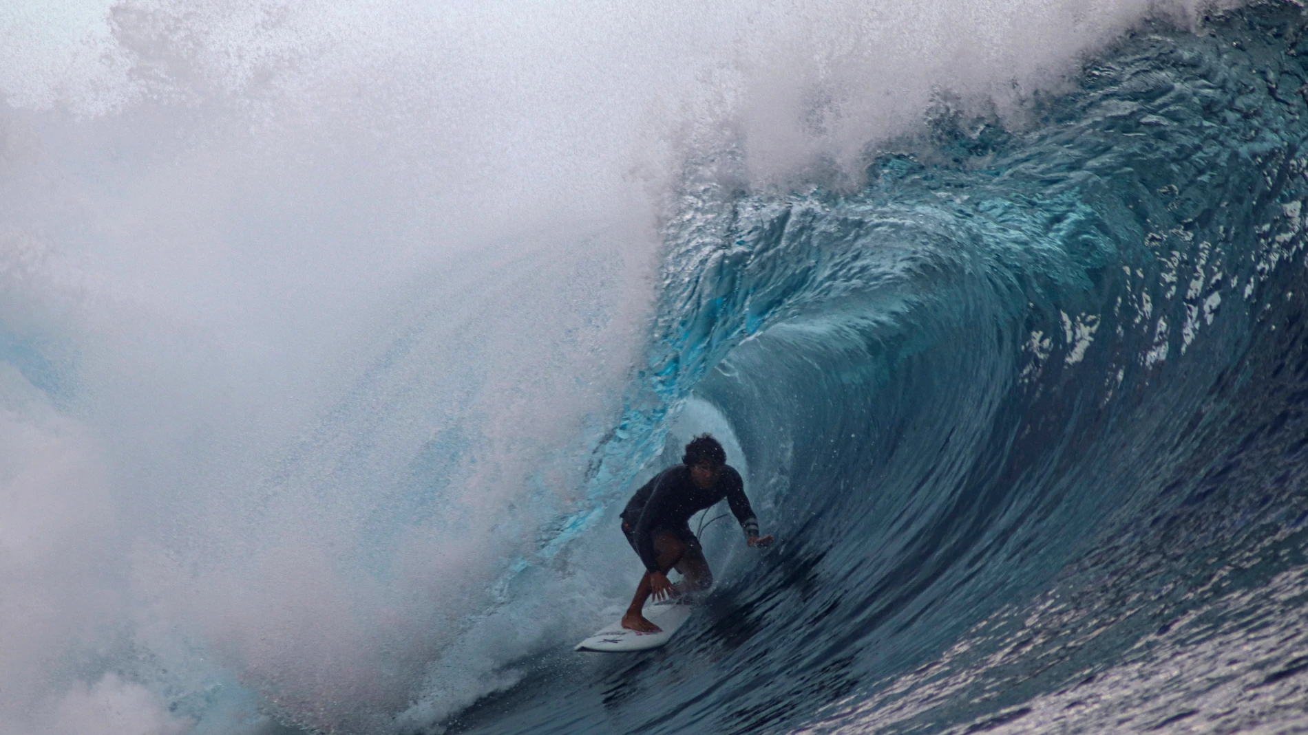 FILE - A surfer rides a wave during the Tahiti Pro surfing competition, a test event for the Paris 2024 Olympics Games in Teahupo'o, French Polynesia in the Pacific Ocean, Friday, Aug. 11, 2023. Organizers of next year's Paris Olympics are scaling back the metal tower they plan to build at the picture-perfect surfing venue in Tahiti, bowing to concerns on the French Polynesian island about damage to sea-life and its majestic Teahupo’o wave. (AP Photo/Esther Cuneo, File)