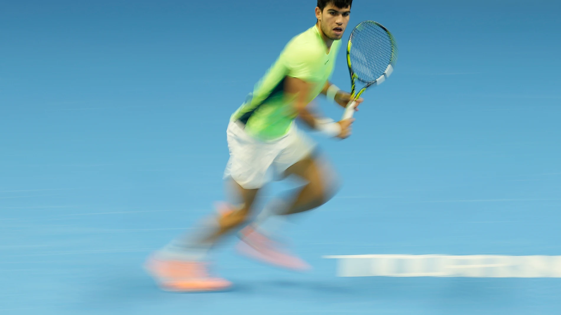 In this image taken with a slow shutter speed, Spain's Carlos Alcaraz returns the ball to Russia's Daniil Medvedev during their singles tennis match of the ATP World Tour Finals at the Pala Alpitour, in Turin, Italy, Friday, Nov. 17, 2023. (AP Photo/Antonio Calanni)