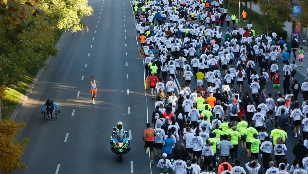 Algunos de los más de 18.000 corredores de la carrera 'Ponle Freno' recorren este domingo el Paseo de Recoletos de Madrid