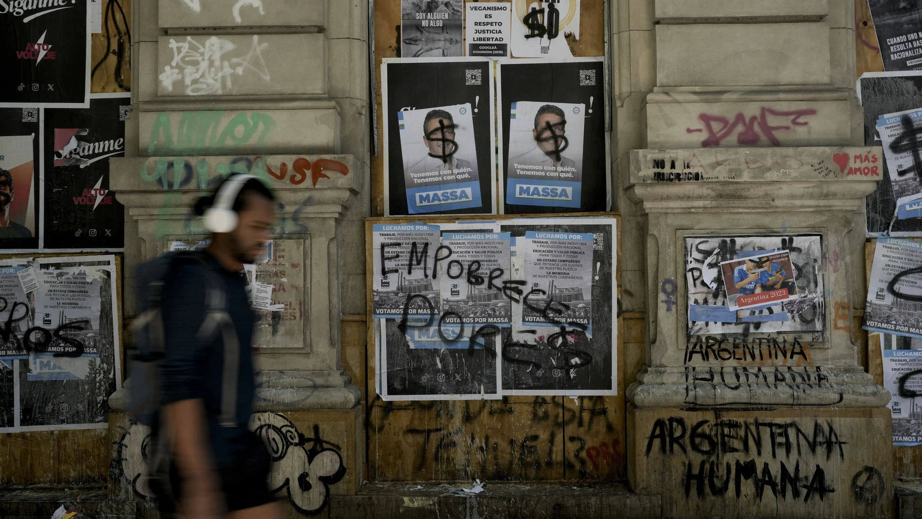 A man walks near a posters of Sergio Massa, Argentine Economy Minister and presidential candidate for the ruling party, in Buenos Aires, Argentina, Saturday, Nov. 18, 2023. Massa will face Liberty Advances coalition candidate Javier Milei in a runoff election on Nov. 19. (AP Photo/Rodrigo Abd)