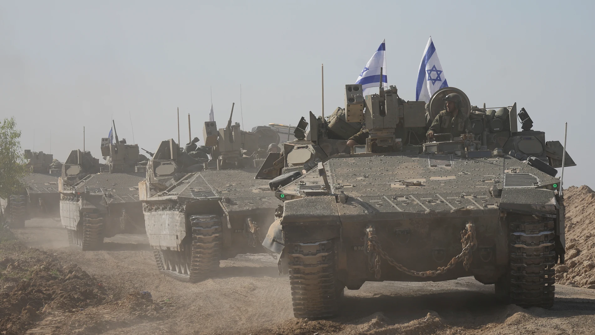 A convoy of Israeli army vehicles maneuvers near Israel's border after leaving Gaza, southern Israel, on Friday, Nov. 24, 2023. Friday marks the start of a four-day cease-fire in the Israel-Hamas war, during which the Gaza militants pledged to release 50 hostages in exchange for 150 Palestinians imprisoned by Israel. (AP Photo/Tsafrir Abayov)