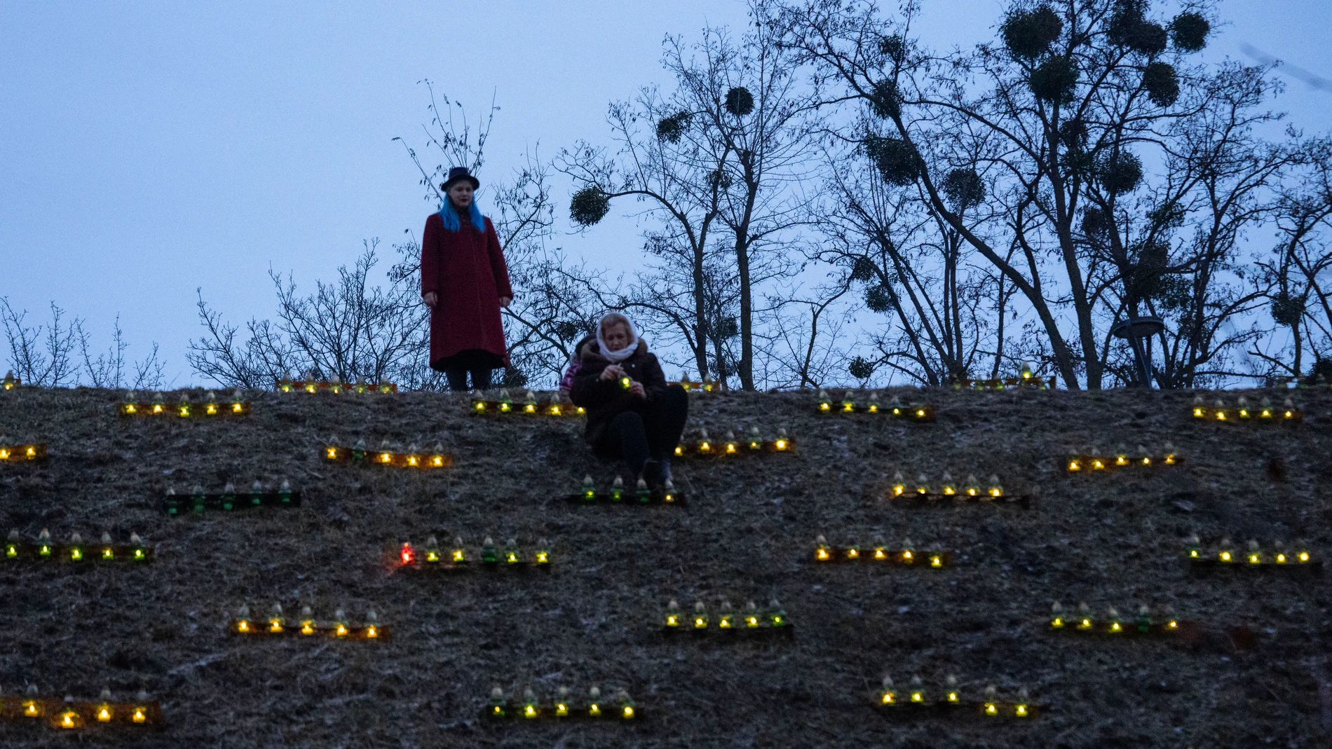 People light candles on a hill at a monument to victims of the 1932-33 Great Famine in Kyiv, Ukraine, Saturday, Nov. 25, 2023. Church bells tolled, candles flickered and national flags, adorned with black ribbons, flew in the Ukrainian capital Kyiv Saturday, amid the second year of the Russian invasion of Ukraine, as the country marked the anniversary of the start of a Soviet-era famine that killed millions. (AP Photo/Efrem Lukatsky)