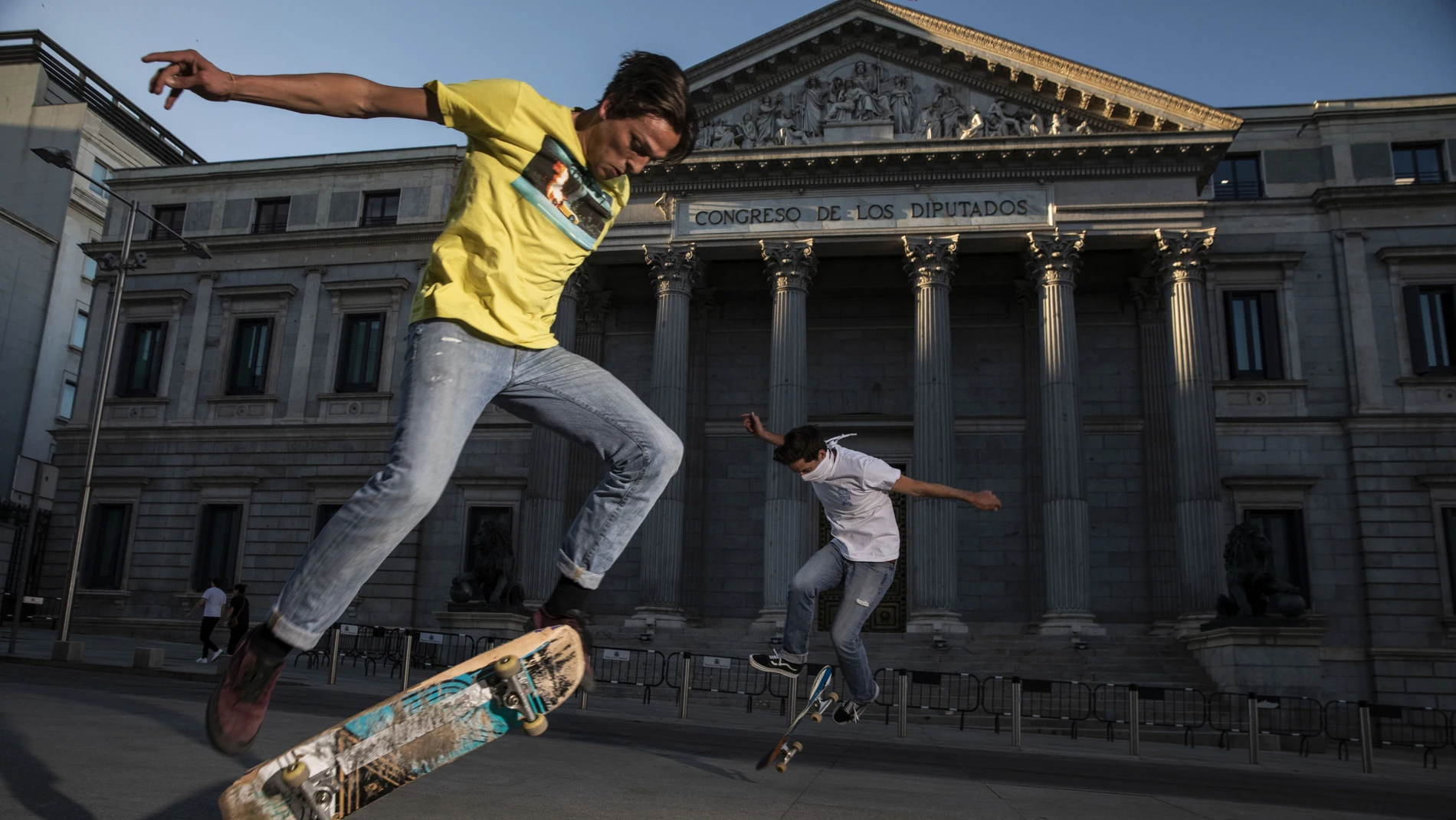 Dos jovenes practican skate delante del congreso 