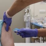 Una mujer se vacuna durante el inicio de la campaña de vacunación frente a la gripe y la Covid-19