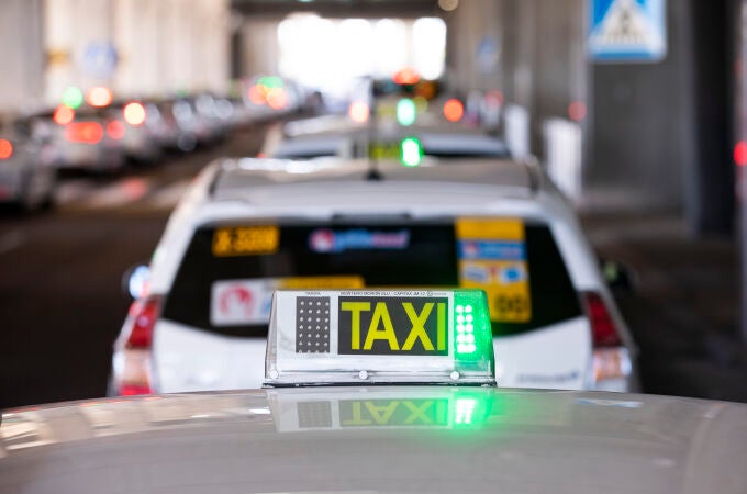 Imagen de una luz de taxi en verde sobre uno de ellos en la T4 de Madrid..
