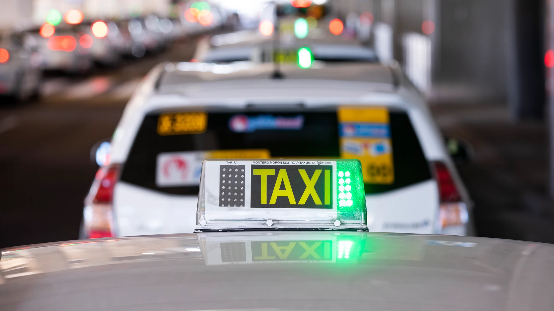 Imagen de una luz de taxi en verde sobre uno de ellos en la T4 de Madrid..