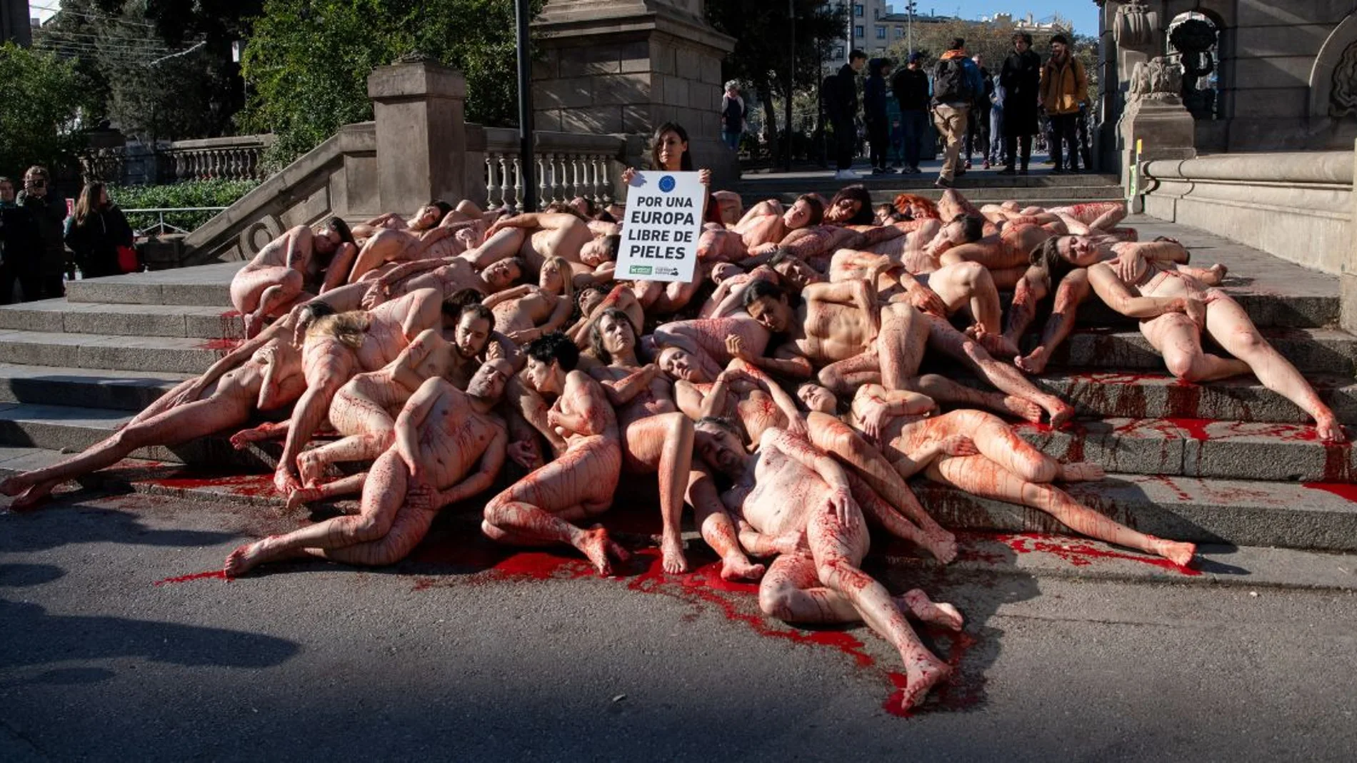 Activistas se desnudan y se cubren de sangre artificial en la Plaza Catalunya de Barcelona 