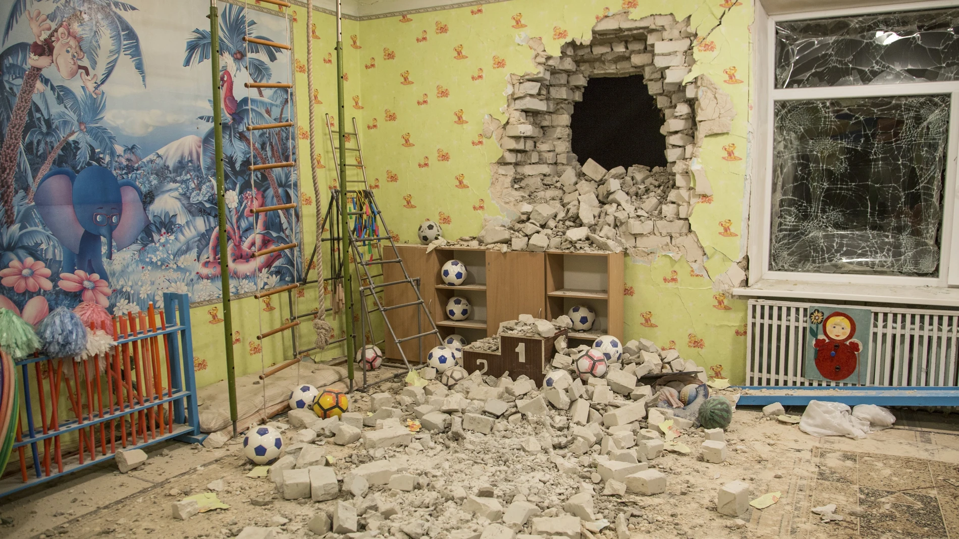 A debris mixes with toys below a damaged wall after the reported shelling on a kindergarten in the settlement of Stanytsia Luhanska, Ukraine.