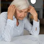Una mujer anciana hace un puzle