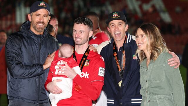 Ryan Reynolds junto al futbolista Anthony Forde que sujeta a su hija 