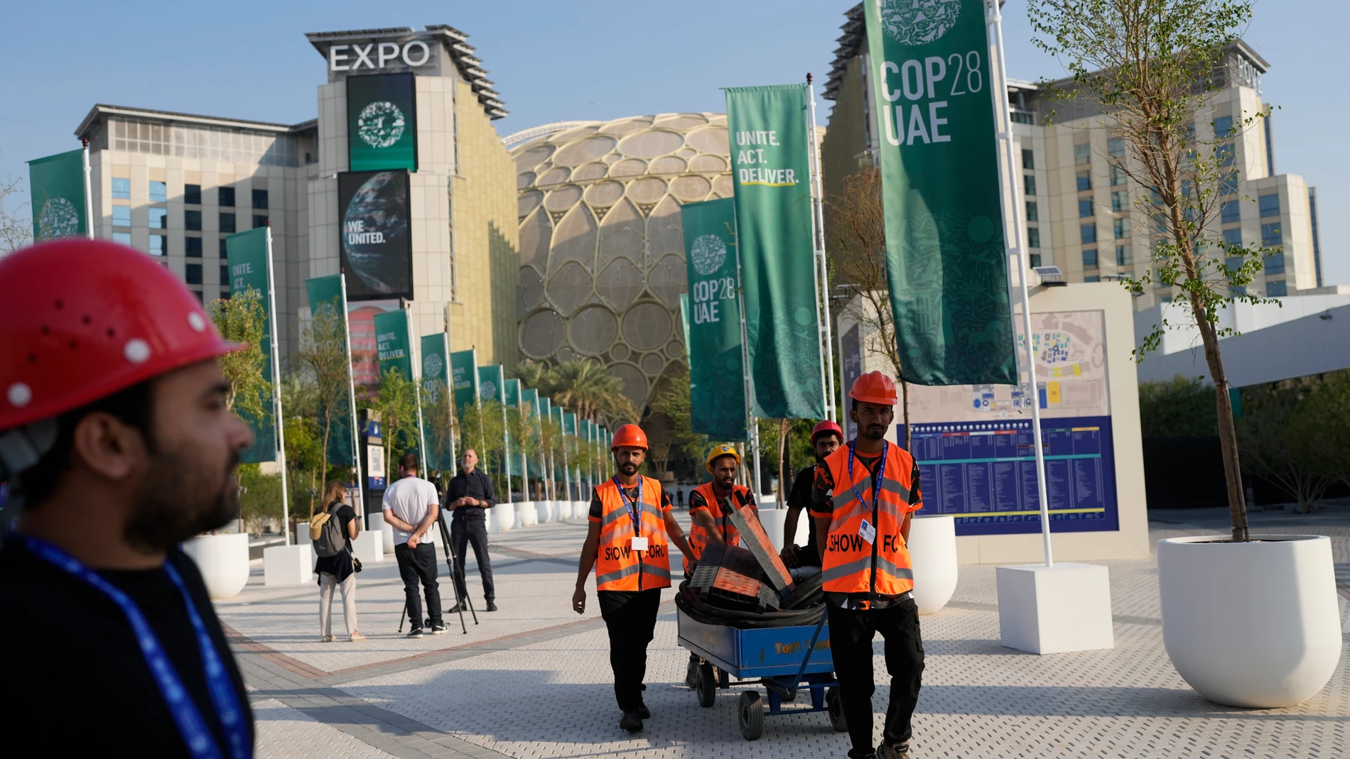 Workers move items as the COP28 U.N. Climate Summit comes to an end, Wednesday, Dec. 13, 2023, in Dubai, United Arab Emirates. (AP Photo/Rafiq Maqbool)