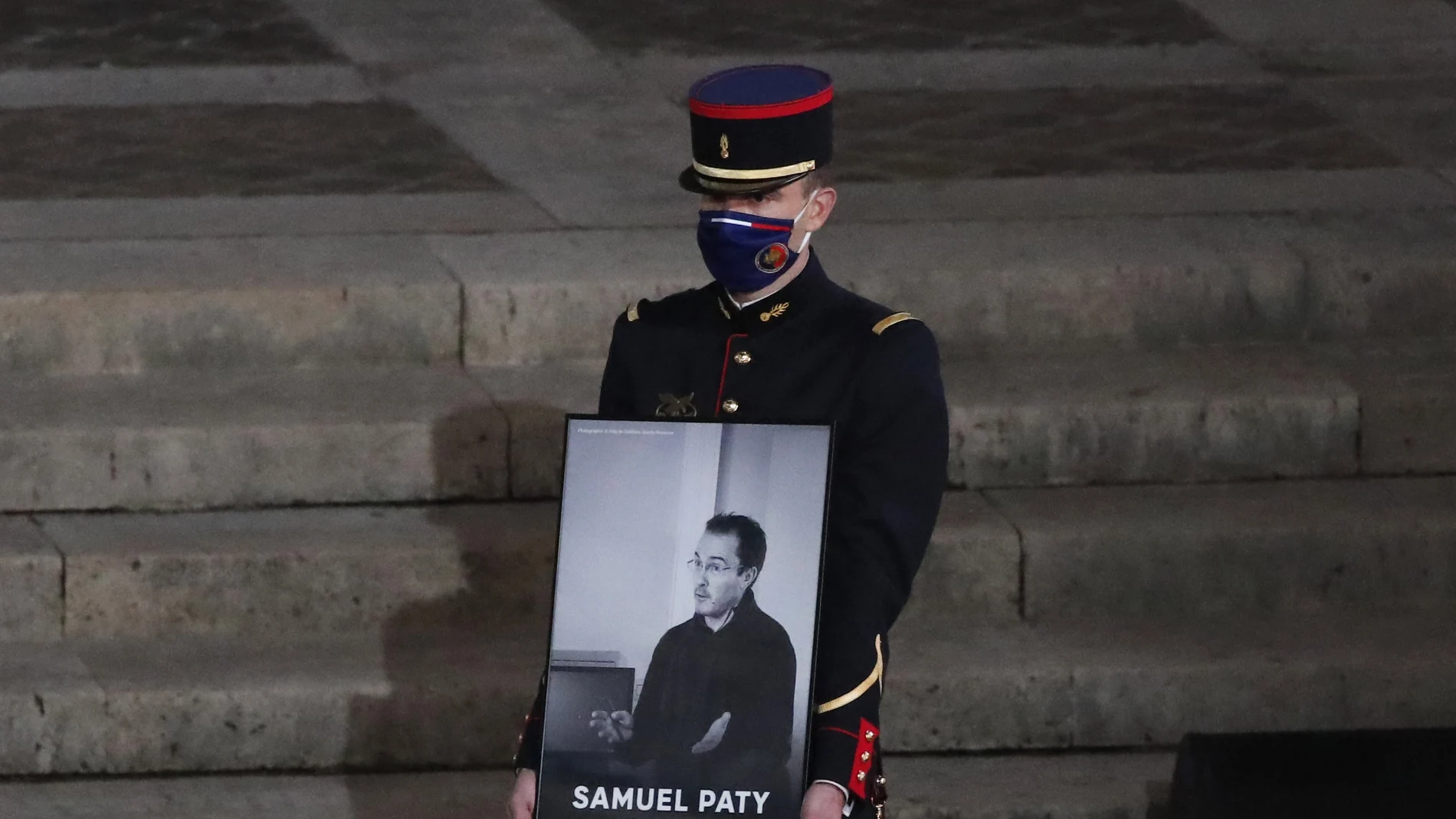 Un guardia republicano muestra un retratato del profesor asesinado Samuel Paty
