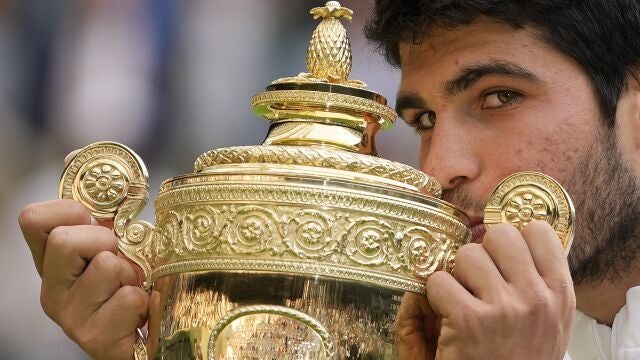 Carlos Alcaraz besa el título de campeón en Wimbledon