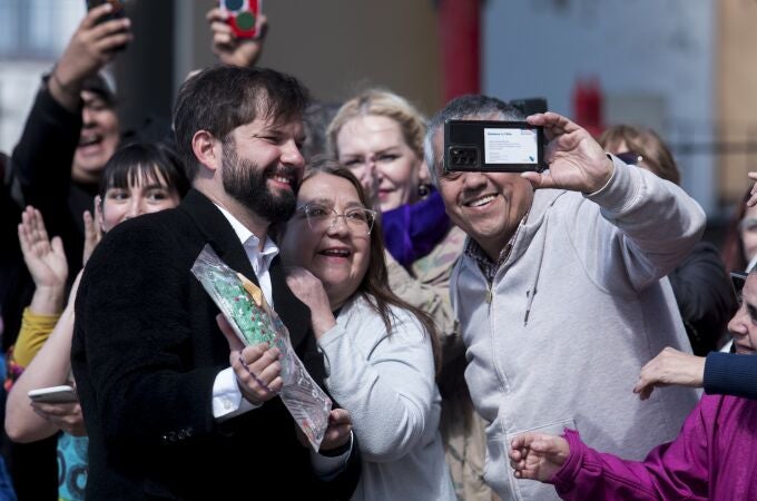 Chile's President Gabriel Boric, left, poses for a picture with supporters as he arrives to vote on the draft of a new constitution in Punta Arenas, Chile.