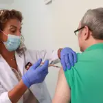 Una enfermera de un centro de salud de Sevilla vacuna a un hombre de la gripe