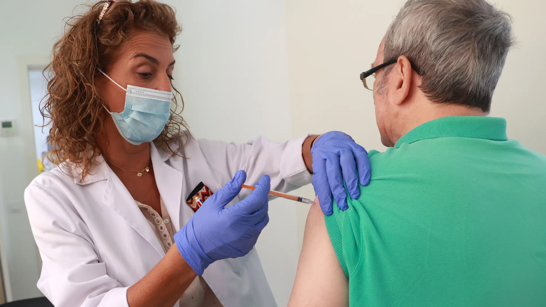 Una enfermera de un centro de salud de Sevilla vacuna a un hombre de la gripe