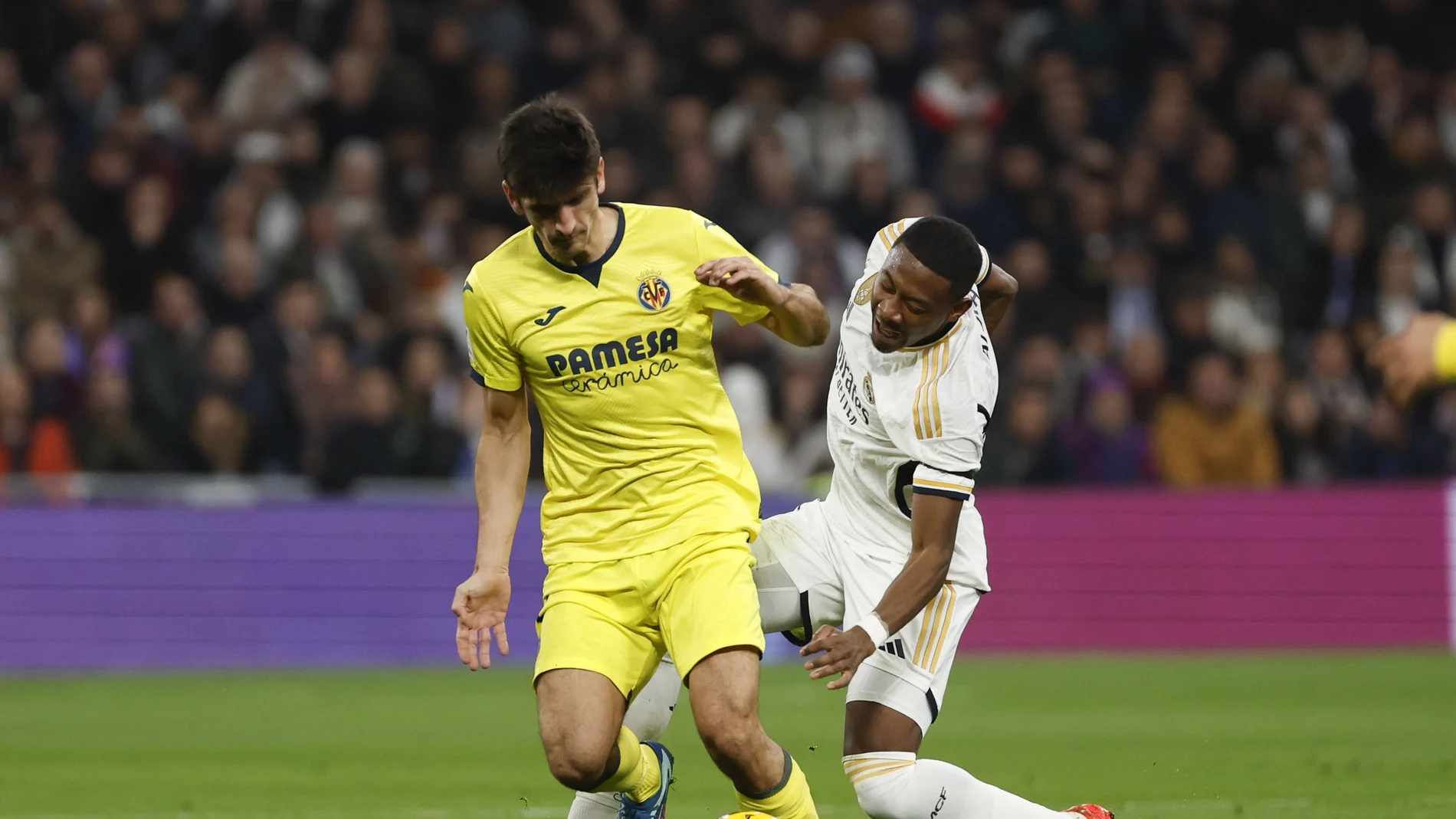 El defensa austriaco del Real Madrid David Alaba (d) en el momento de lesionarse ante Gerard Moreno, del Villarreal, durante el partido de la jornada 17 de Liga en Primera División que Real Madrid y Villarreal CF disputan hoy domingo en el estadio Santiago Bernabéu. 