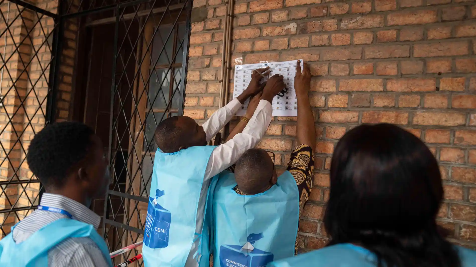 Election officials put up voters lists outside a voting station during the presidential elections in Kinshasa, Democratic Republic of Congo, Wednesday, Dec. 20, 2023. Congo headed to the polls Wednesday to vote for president as authorities scrambled to finalise preparations in an election facing steep logistical and security challenges. (AP Photo/Mosa'ab Elshamy)