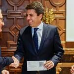 El presidente de la Generalitat, Carlos Mazón, recibe el informe de la Cuenta General, de manos del Síndic major de Comptes, Vicent Cucarella
