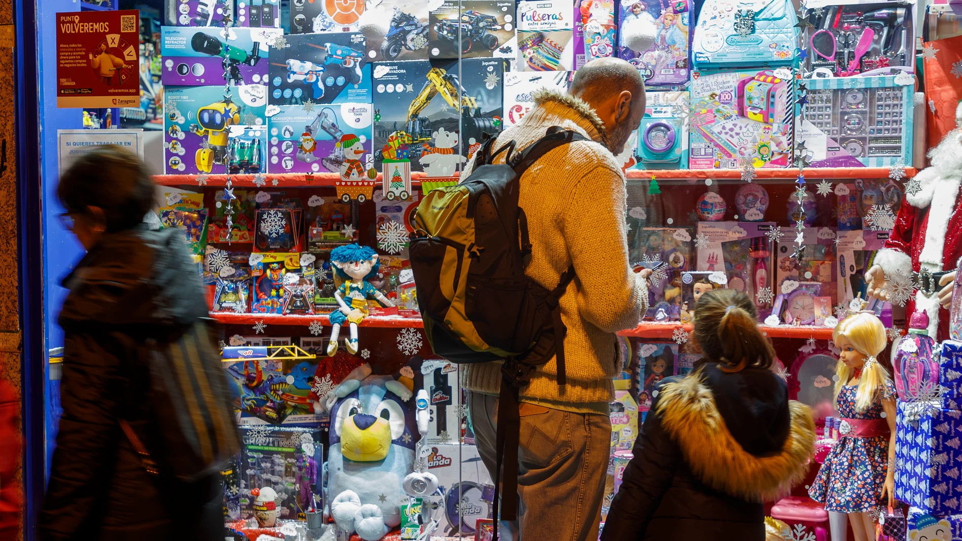 ZARAGOZA (ARAGÓN), 23/12/2023.- Dos personas frente al escaparate de una juguetería en Zaragoza, este sábado. La campaña de juguetes para Navidad comienza con la llegada de Papá Nöel. Según la Asociación Española de Fabricantes de Jugüetes (AEFJ) el 75% de los jugüetes son comprados en Navidad. EFE/ Javier Belver 