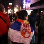 Un manifestante protesta en Belgrado envuelto en la bandera serbia