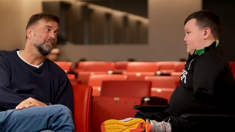 Jürgen Klopp junto a un joven aficionado del Liverpool