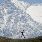 Una persona corre frente a la cordillera de Dhauladhar en la aldea de Jalot, Himachal Pradesh, India, el 22 de abril de 2020. La cordillera de Dhauladhar es parte de la cadena menor de montañas del Himalaya, siendo Hanuman Tibb el pico más alto con casi 6,000 metros. 