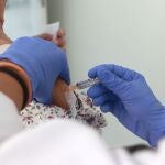 Una mujer se vacuna contra el virus de la gripe