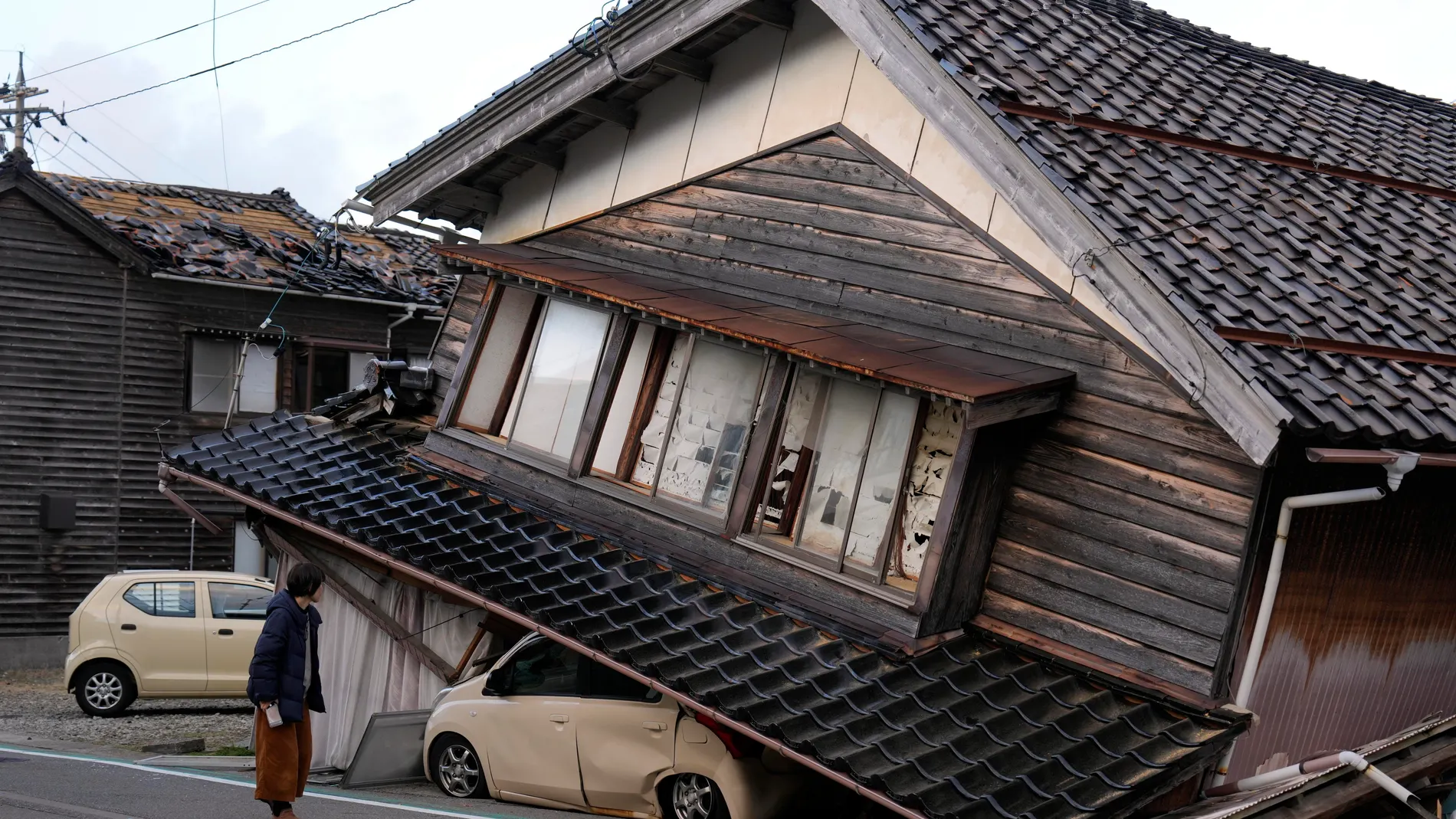 -FOTODELDIA- TOGI TOWN (Japón), 02/01/2024.- Una mujer observa una vivienda y vehículos dañados tras un fuerte terremoto en Tohi Town, en la península de Noto, Japón, este 02 de enero de 2024. Las víctimas del terremoto de 7,6 grados que golpeó el litoral occidental de Japón ascienden ya a 30, mientras se subraya la dificultad de los equipos de rescate y fuerzas de seguridad para acceder a las zonas más afectadas por el seísmo. EFE/FRANCK ROBICHON 