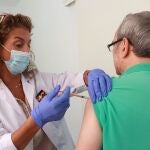 Una sanitaria inocula la vacuna de la gripe a un hombre