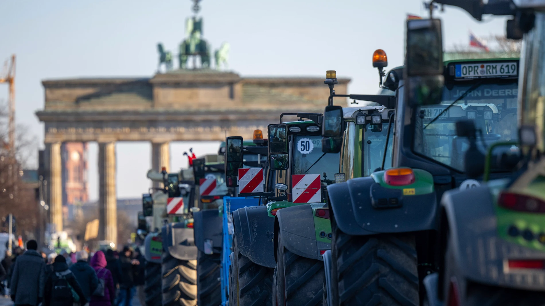Numerous tractors stand in front of the Brandenburg Gate during a farmers' protest in Berlin, Germany, Monday, Jan. 8, 2024. Farmers blocked highway access roads in parts of Germany Monday and gathered for demonstrations, launching a week of protests against a government plan to scrap tax breaks on diesel used in agriculture. (Monika Skolimowska/dpa via AP)