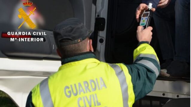 Un agente de la Guardia Civil realiza una prueba de control de alcoholemia a un conductor