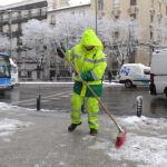 Operario de limpieza municipal retira nieve de las aceras de la capital