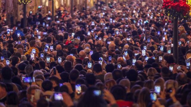 FILED - 30 November 2021, Spain, Malaga: People hold their mobile phones ahead of the start of Christmas lighting in Marques de Larios street. As every year, the Christmas lights welcomes Christmas season in downtown city. Despite the rise of infections in the city, thousands of people have gathered to watch the Christmas lights show. Photo: -/ZUMA Press Wire/dpa 30/11/2021 ONLY FOR USE IN SPAIN