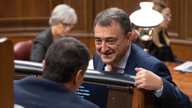 El presidente del Gobierno, Pedro Sánchez (i), conversa con el portavoz del PNV en el Congreso, Aitor Esteban (d), durante un pleno en el Congreso de los Diputados.