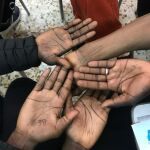 Las manos de los inmigrantes con un número en las manos 