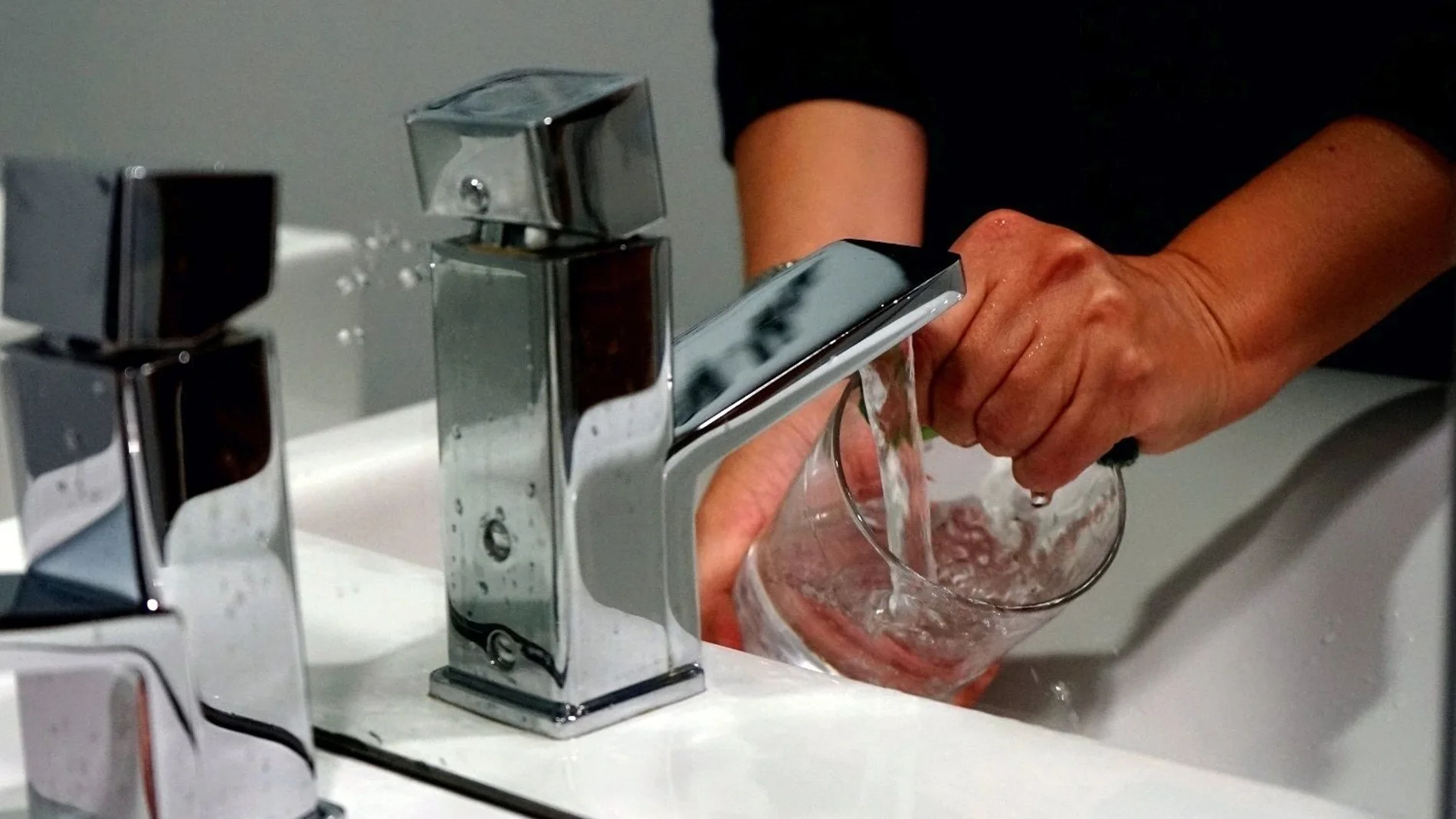 Una persona lavando un grifo en una pila de agua