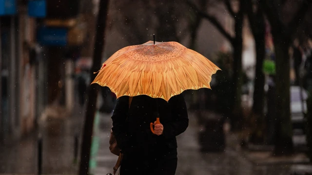 Una persona se protege de la lluvia con paraguas