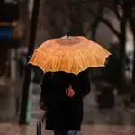 Una persona se protege de la lluvia con paraguas